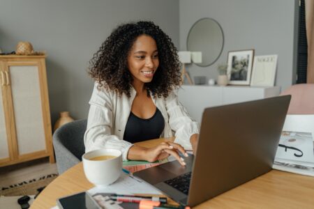 A woman smiling and looking at her laptop